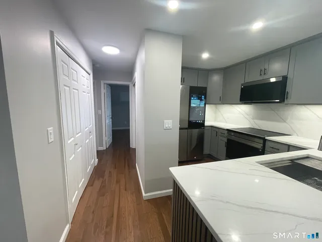 a view of empty room with wooden floor