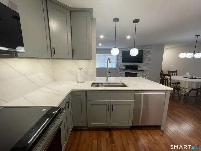 a kitchen with a sink and wooden floor
