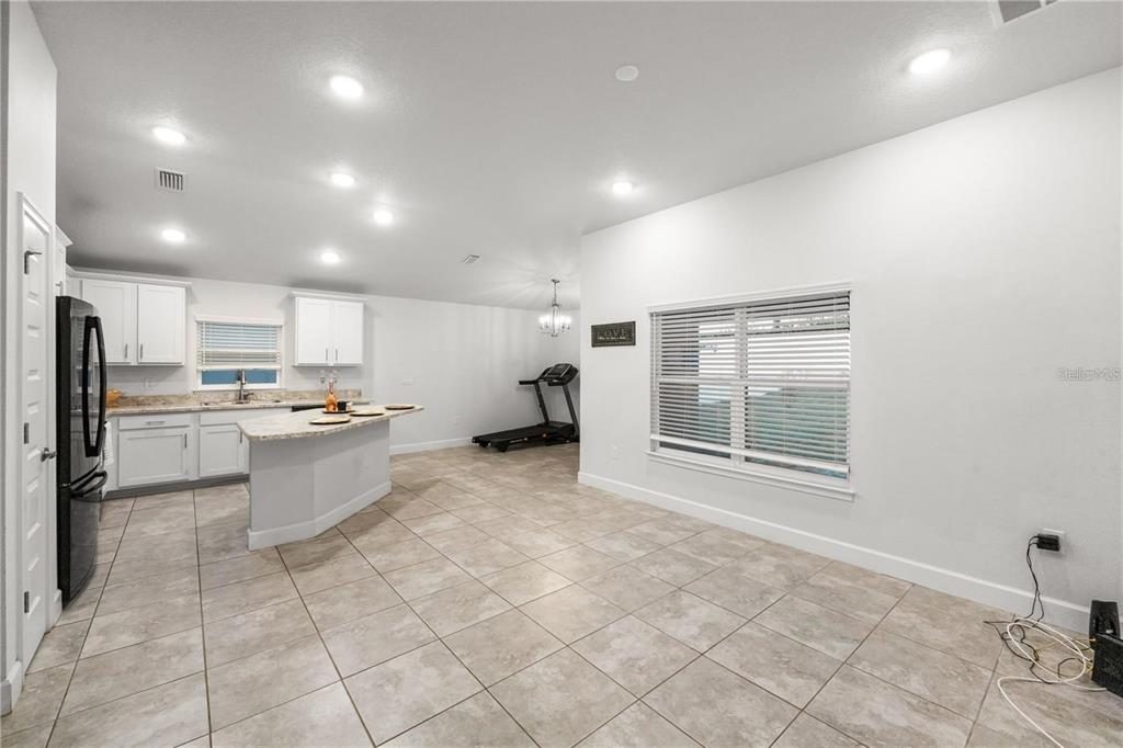 14429 Potterton Circle Hudson, FL 34667 - Photo 11 of 36 a kitchen with stainless steel appliances kitchen island granite countertop a refrigerator and cabinets