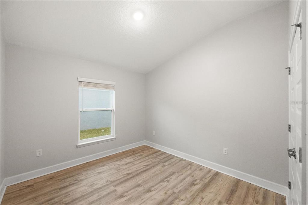 14429 Potterton Circle Hudson, FL 34667 - Photo 13 of 36 wooden floor in an empty room with a window