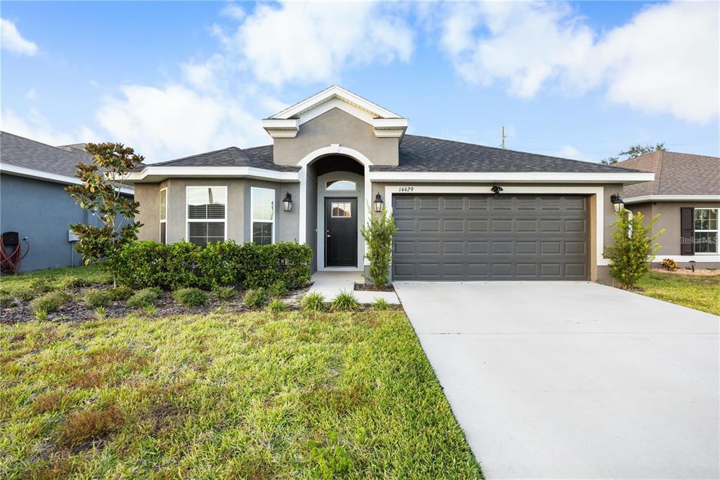 14429 Potterton Circle Hudson, FL 34667 - Photo 3 of 36 a front view of a house with a yard and garage
