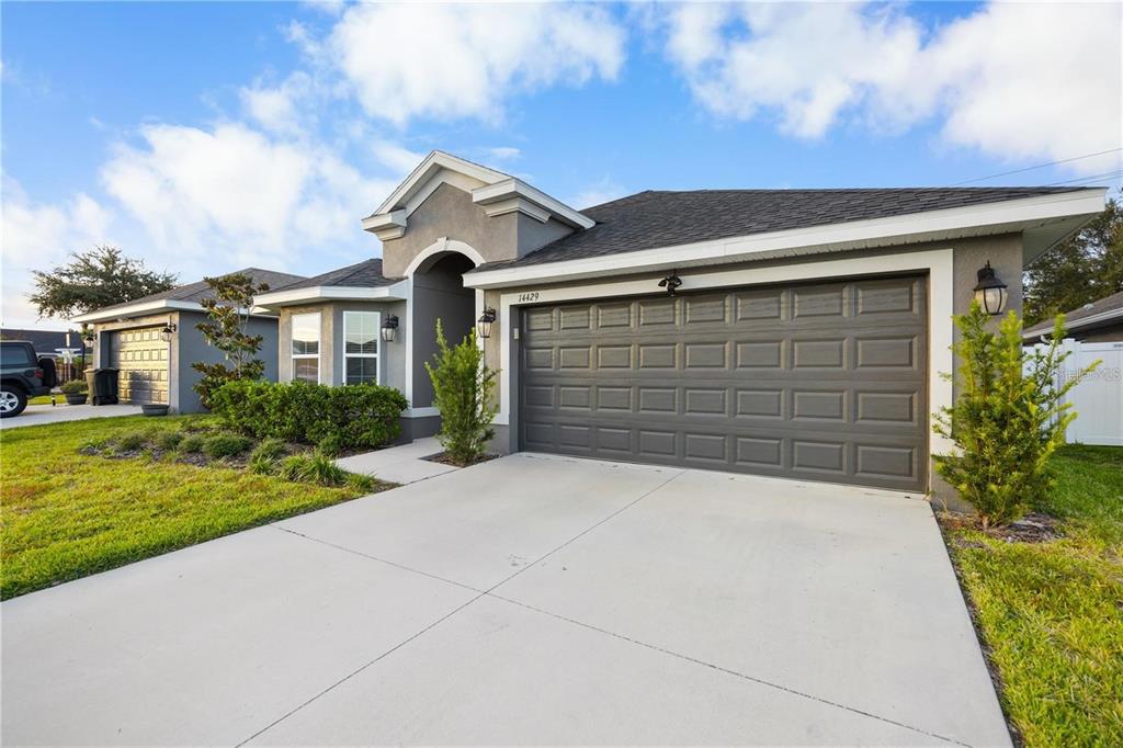 14429 Potterton Circle Hudson, FL 34667 - Photo 34 of 36 a front view of a house with a yard and garage