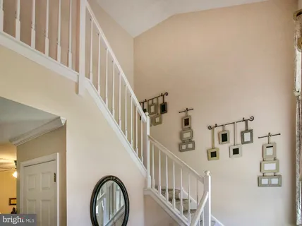 a view of staircase with lots of frames on wall and a large window