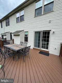 a backyard of a house with wooden floor table and chairs