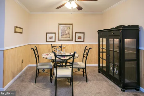 a view of a dining room with furniture and a chandelier fan