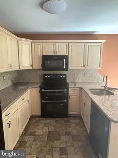 a kitchen with a sink stove and cabinets