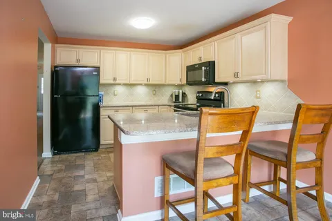 a kitchen with stainless steel appliances granite countertop a refrigerator and microwave