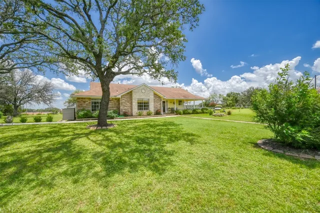 a view of an house with backyard and tree