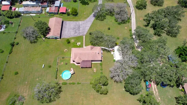 an aerial view of a house with a swimming pool yard and outdoor seating