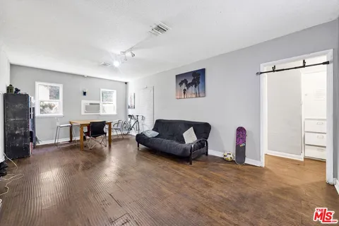 a living room with furniture and a wooden floor