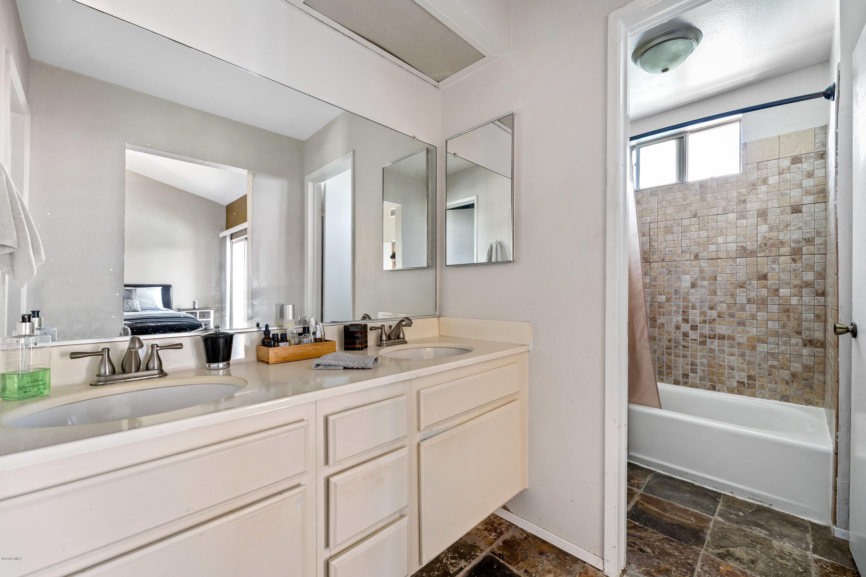 3966 Cochran Street, Unit 72 Simi Valley, CA 93063 - Photo 16 of 26 a bathroom with double vanity sink a mirror and a bathtub