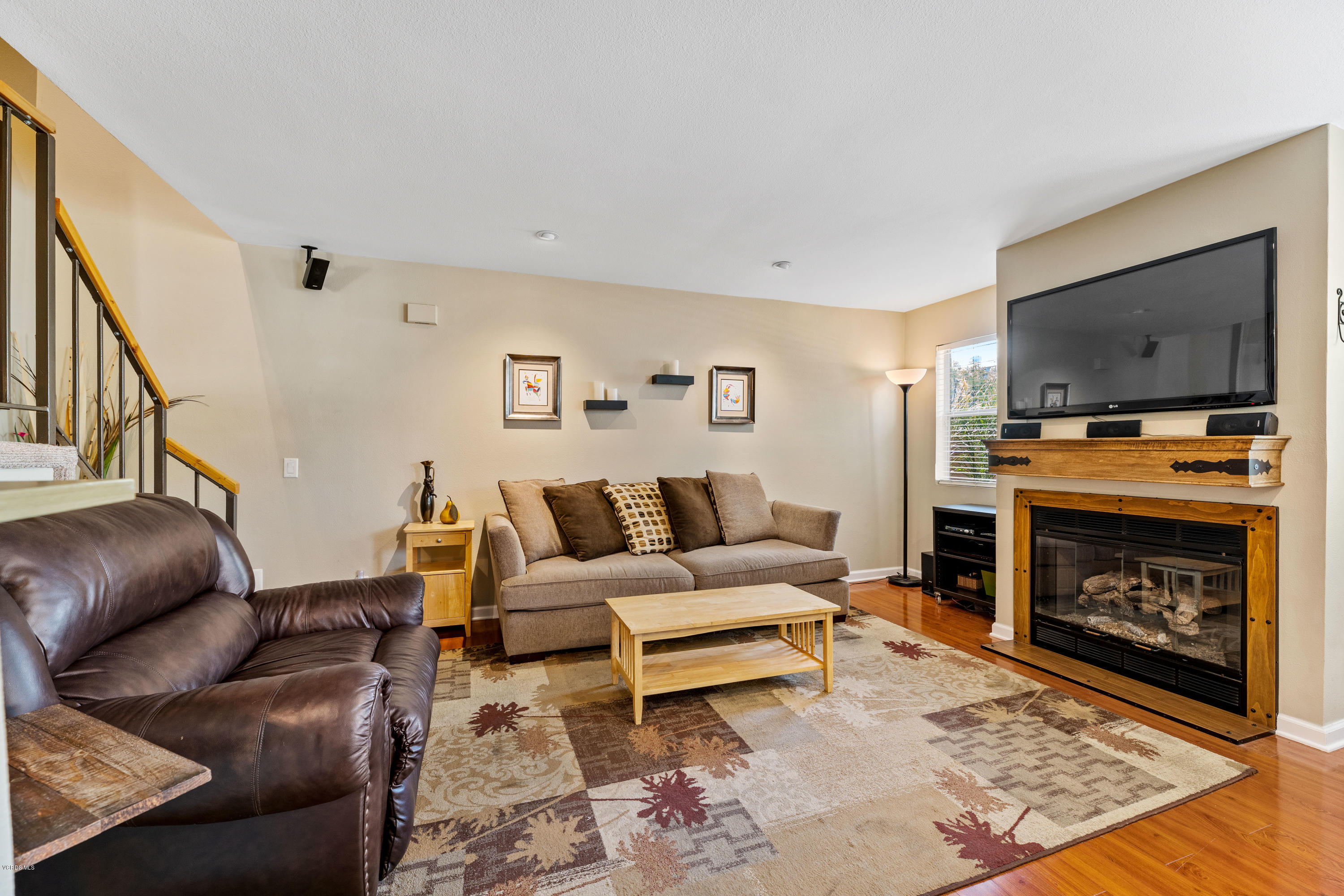 3966 Cochran Street, Unit 72 Simi Valley, CA 93063 - Photo 5 of 26 a living room with furniture a flat screen tv and a fireplace