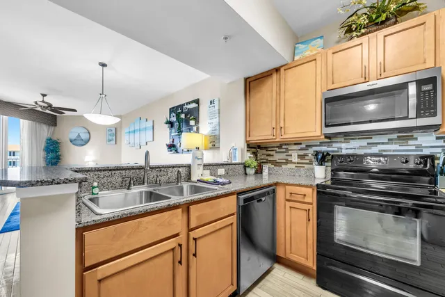 a kitchen with stainless steel appliances a stove sink microwave and cabinets