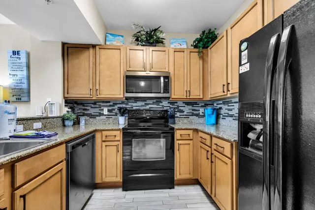a kitchen with granite countertop a refrigerator stove and microwave