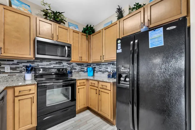 a kitchen with stainless steel appliances granite countertop a refrigerator stove and microwave