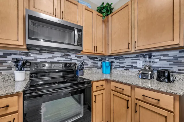 a kitchen with stainless steel appliances granite countertop a stove microwave and cabinets