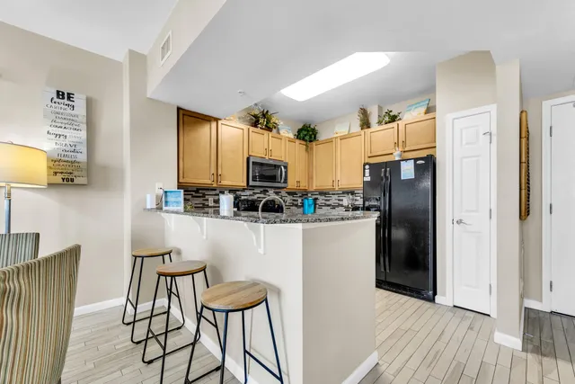 a kitchen with stainless steel appliances a refrigerator and a stove top oven