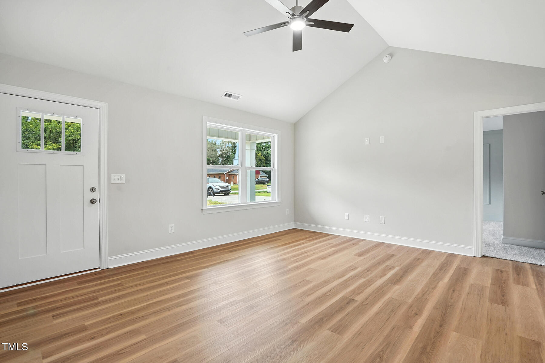8686 Green Path Road Dunn, NC 28334 - Photo 8 of 31 an empty room with wooden floor chandelier fan and windows