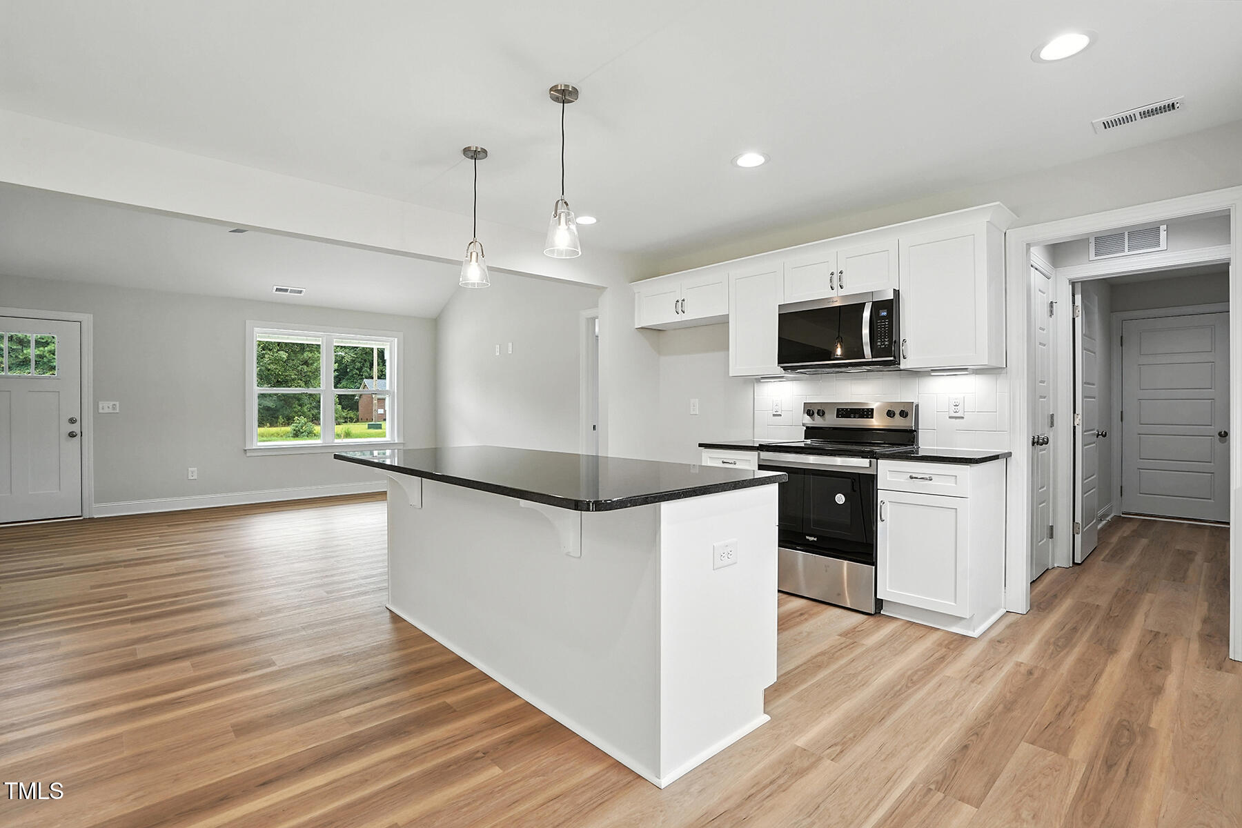 8686 Green Path Road Dunn, NC 28334 - Photo 10 of 31 a kitchen with granite countertop a stove top oven a sink dishwasher a refrigerator and a dining table with wooden floor
