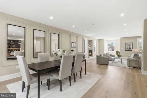 a kitchen with a stove a kitchen island a dining table and chairs with wooden floor