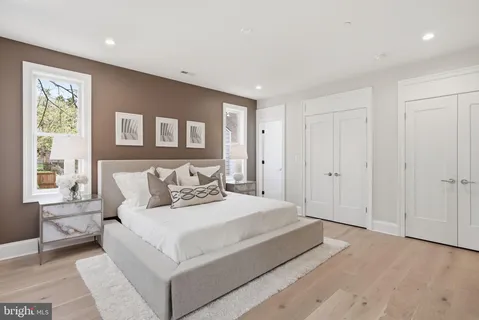 a spacious bedroom with a bed and a lamp