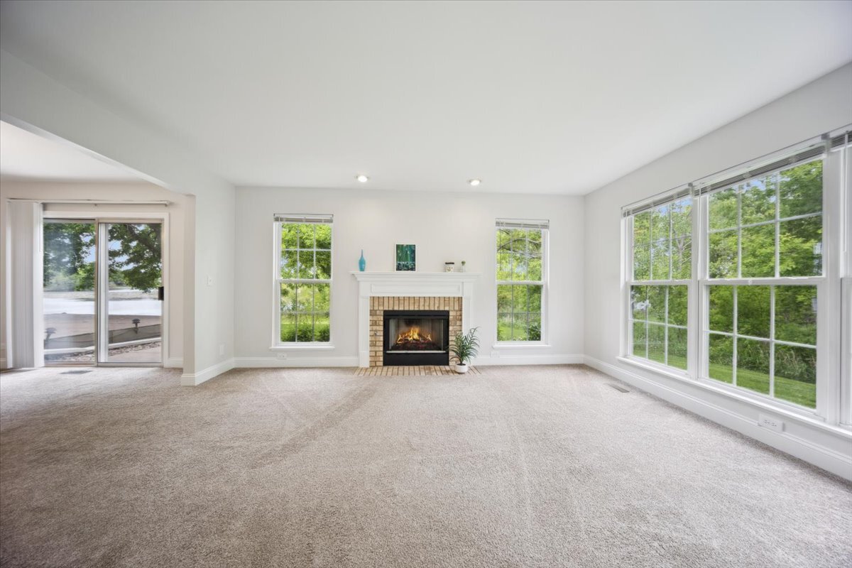 1148 Coldspring Road Elgin, IL 60120 - Photo 7 of 27 a view of an empty room with window and a fireplace