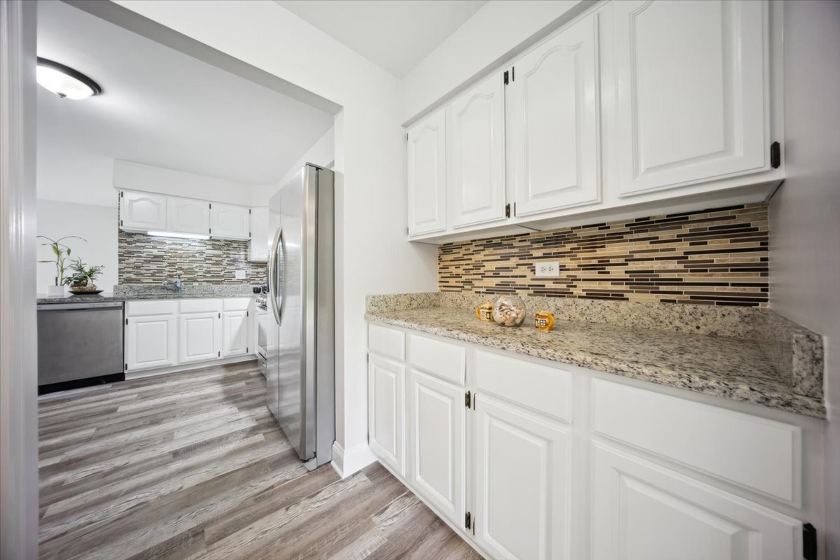 1148 Coldspring Road Elgin, IL 60120 - Photo 10 of 27 a kitchen with granite countertop white cabinets and stainless steel appliances