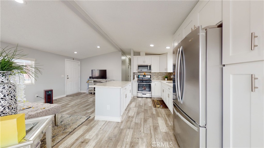 1782 Nisson Road, Unit 7 Tustin, CA 92780 - Photo 11 of 29 a kitchen with white cabinets and stainless steel appliances