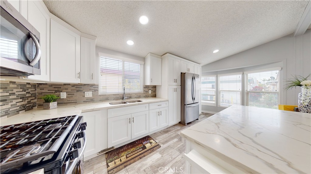 1782 Nisson Road, Unit 7 Tustin, CA 92780 - Photo 15 of 29 a large kitchen with a large window and stainless steel appliances