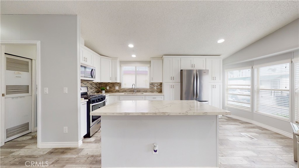 1782 Nisson Road, Unit 7 Tustin, CA 92780 - Photo 3 of 29 a kitchen with stainless steel appliances granite countertop a refrigerator and a sink