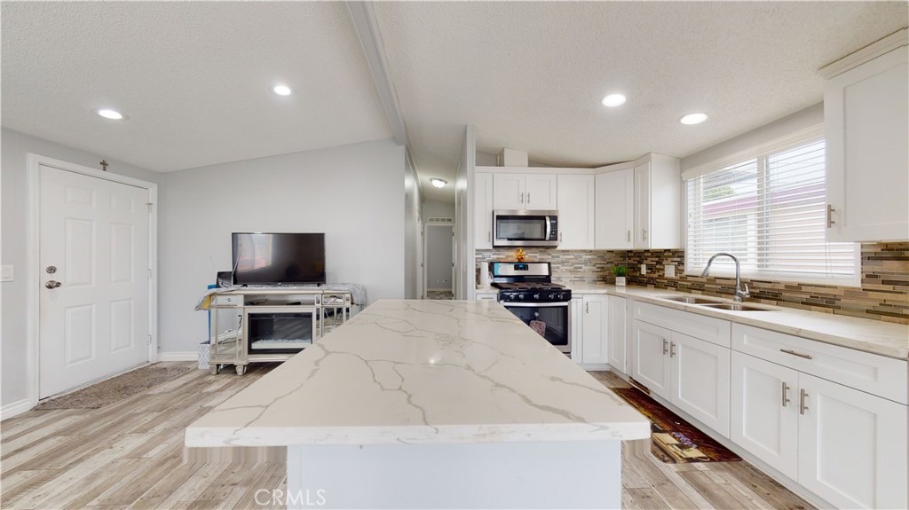 1782 Nisson Road, Unit 7 Tustin, CA 92780 - Photo 7 of 29 a large kitchen with kitchen island a sink stainless steel appliances and cabinets