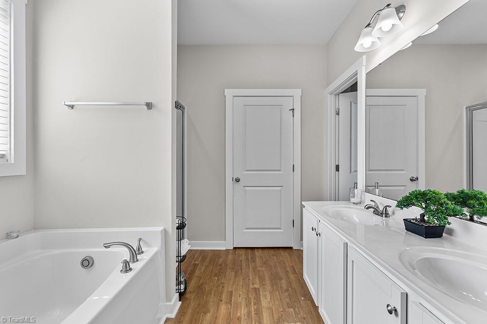 442 Weatherly Street Ramseur, NC 27316 - Photo 16 of 28 Primary bath, double vanity, tub, shower, toilet room, and walk in closet.