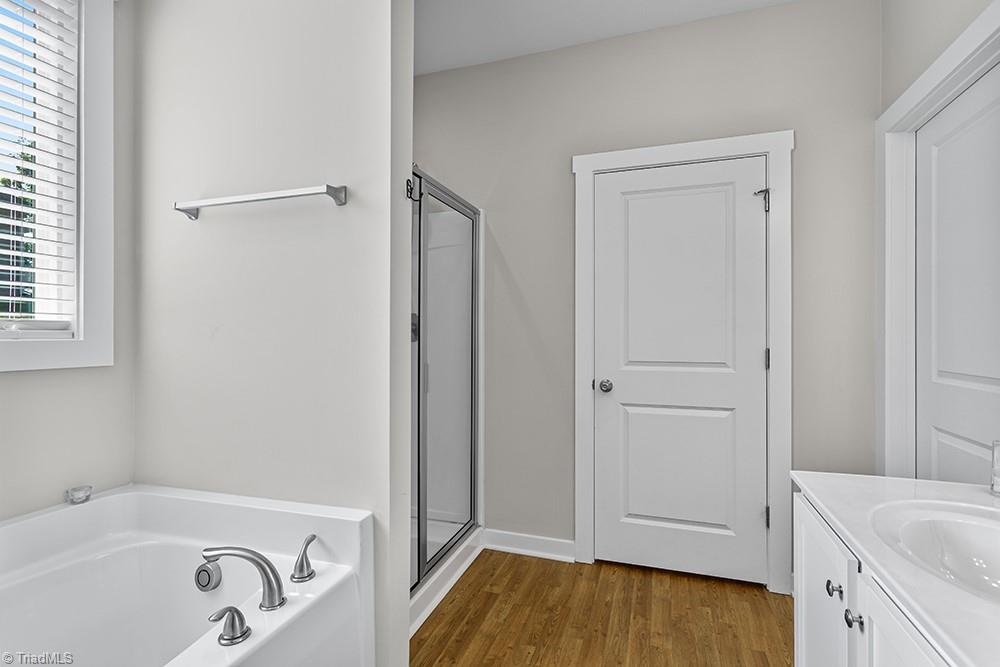 442 Weatherly Street Ramseur, NC 27316 - Photo 17 of 28 Primary bath, double vanity, tub, shower, toilet room, and walk in closet.