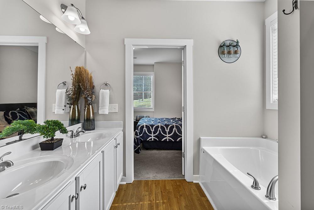 442 Weatherly Street Ramseur, NC 27316 - Photo 19 of 28 Primary bath, double vanity, tub, shower, toilet room, and walk in closet.