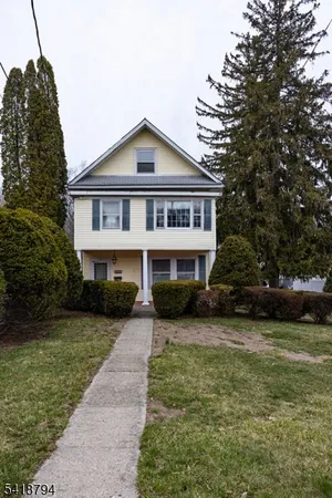 a front view of a house with a garden and trees