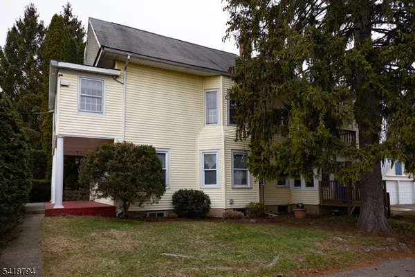 a view of a house with a yard and tree
