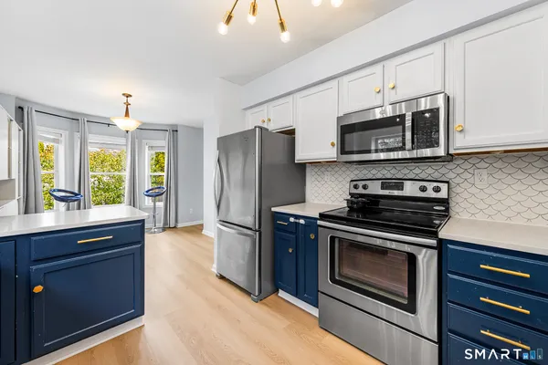 a kitchen with stainless steel appliances granite countertop a stove a refrigerator and a microwave