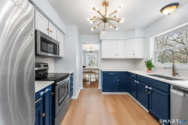 a kitchen with stainless steel appliances granite countertop a sink stove and microwave