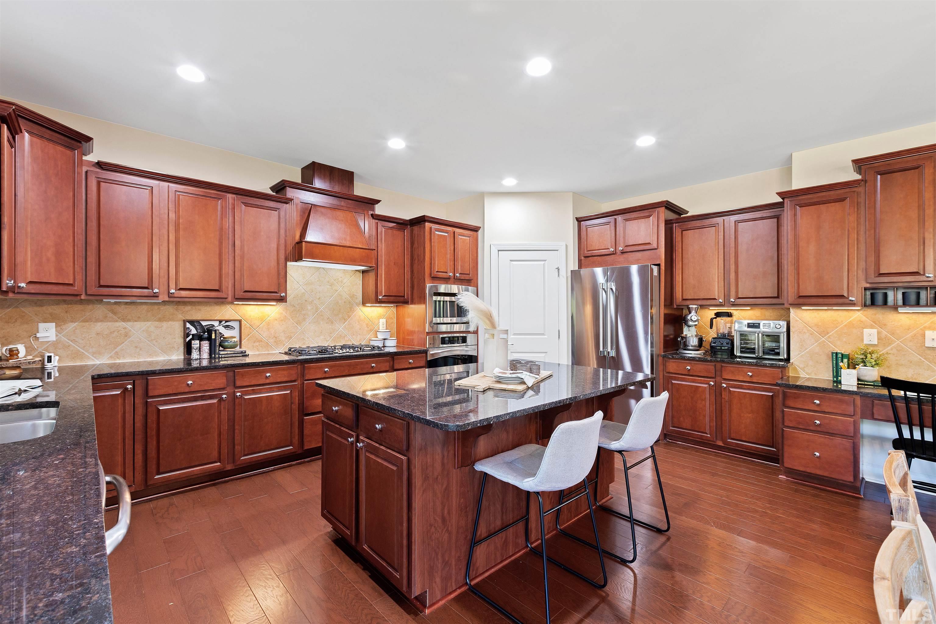 400 Alliance Circle Cary, NC 27519 - Photo 16 of 62 a kitchen with stainless steel appliances granite countertop a table chairs sink refrigerator and cabinets