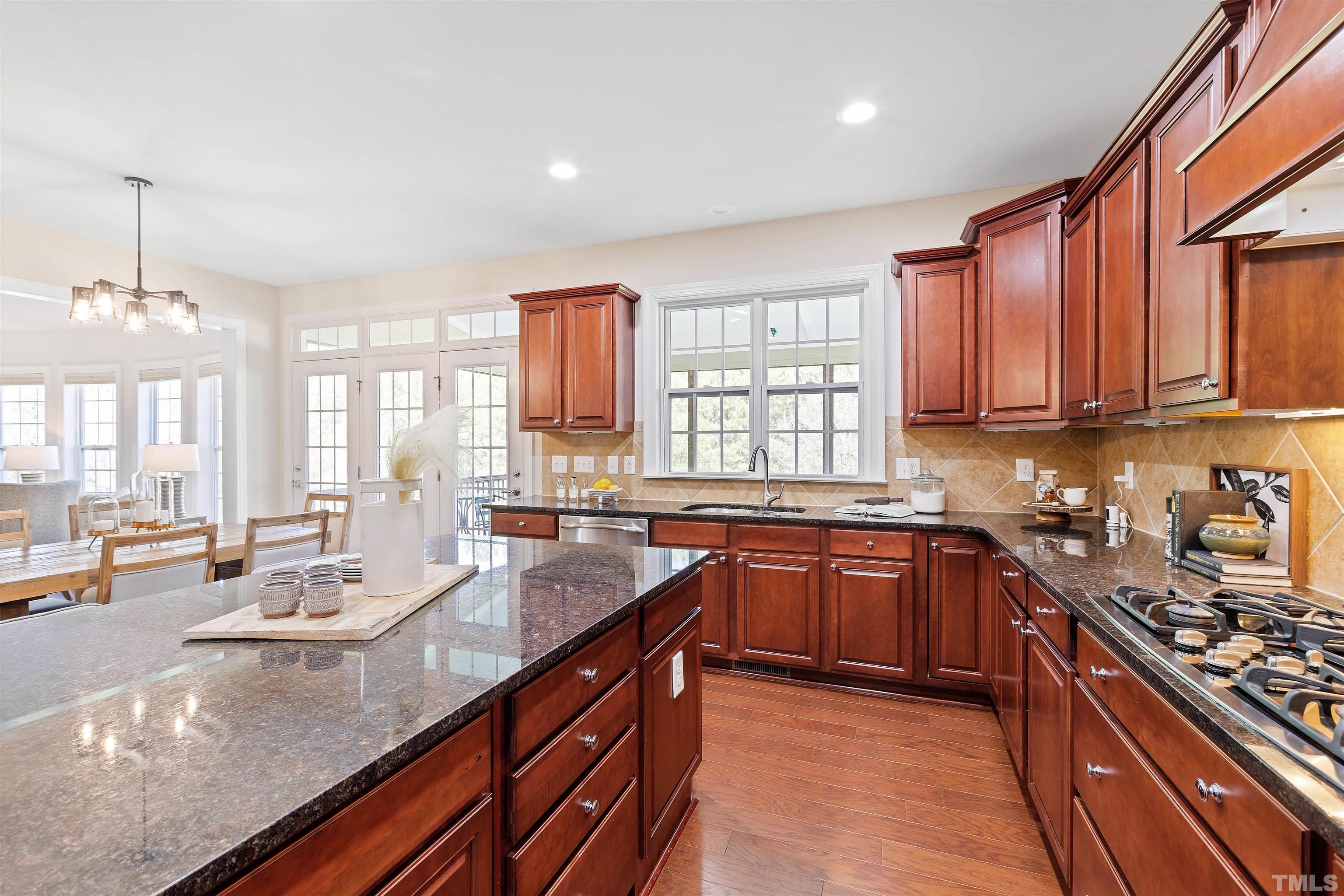 400 Alliance Circle Cary, NC 27519 - Photo 18 of 62 a large kitchen with granite countertop a large counter top space a sink stainless steel appliances and cabinets