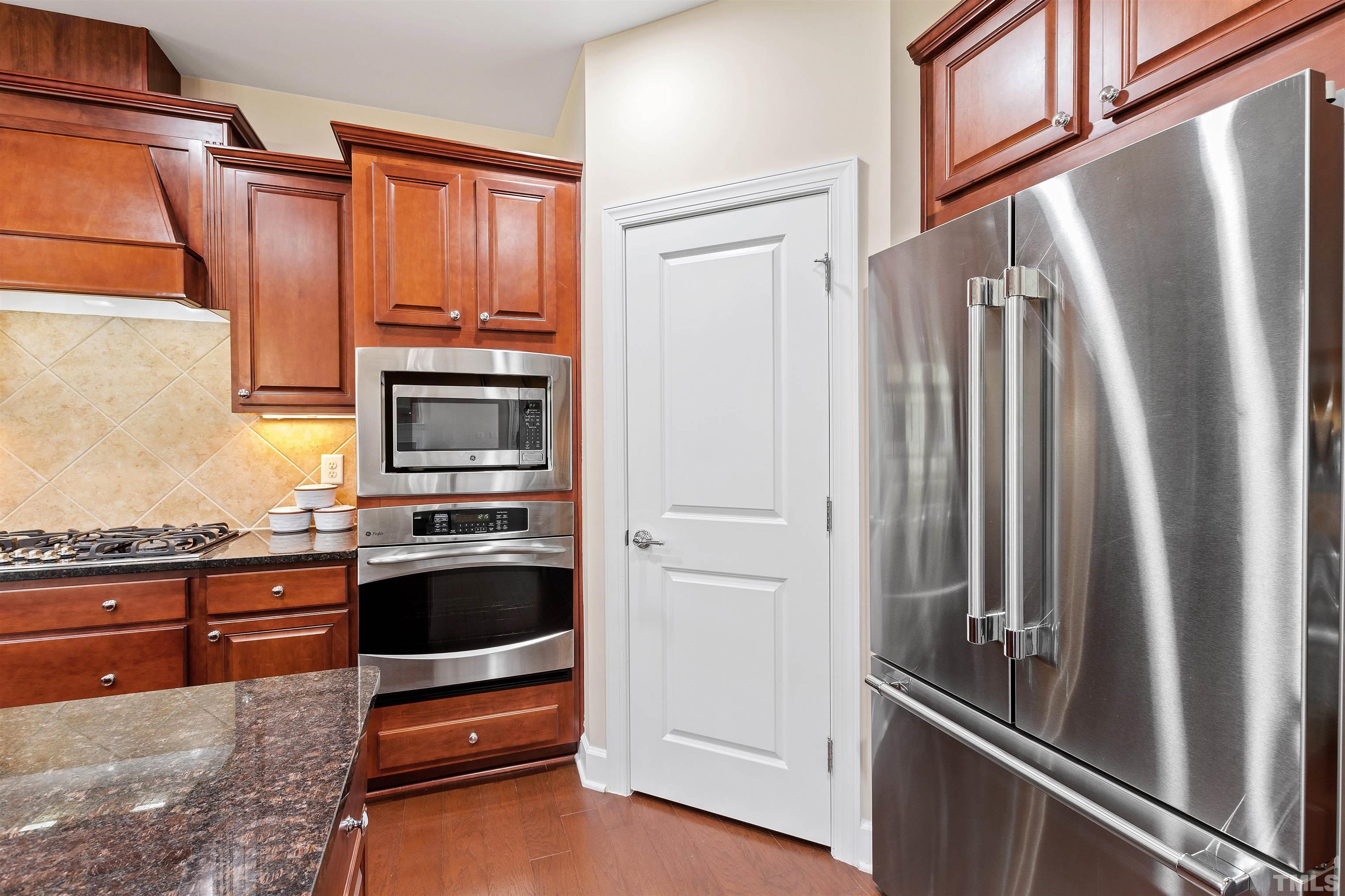 400 Alliance Circle Cary, NC 27519 - Photo 20 of 62 a kitchen with granite countertop a refrigerator and a stove top oven