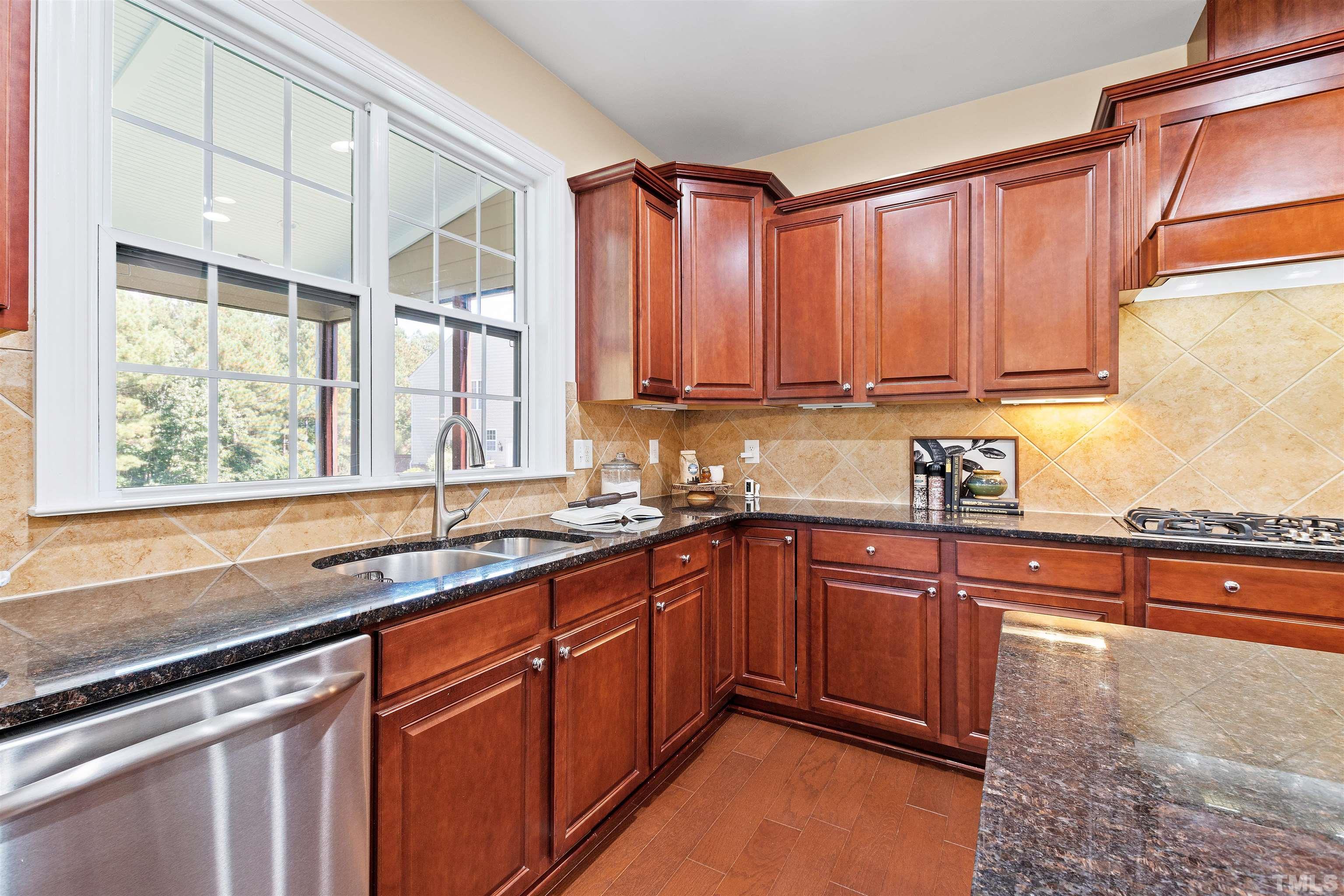 400 Alliance Circle Cary, NC 27519 - Photo 24 of 62 a kitchen with stainless steel appliances granite countertop wooden cabinets a sink and a large window