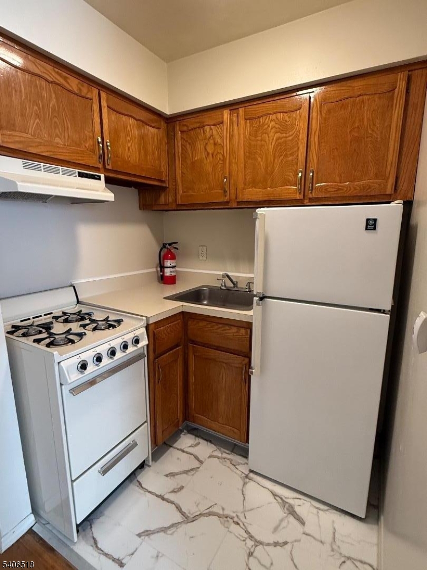 a kitchen with stainless steel appliances granite countertop a refrigerator stove a sink and dishwasher
