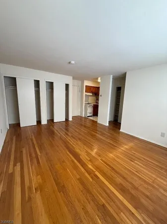 a view of a big room with wooden floor and windows