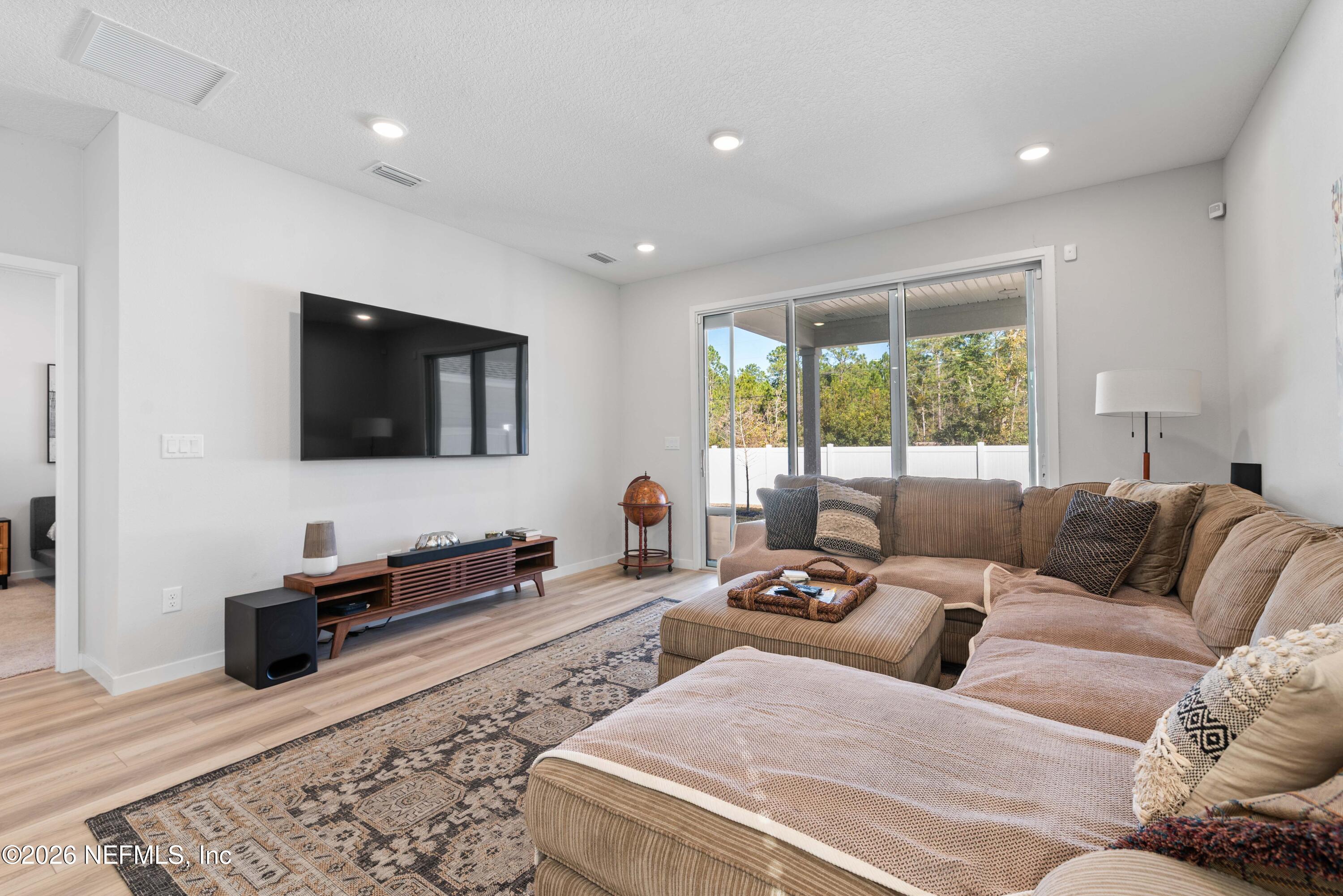 96245 Broadmoore Road Fernandina Beach, FL 32034 - Photo 11 of 33 a living room with furniture and a flat screen tv