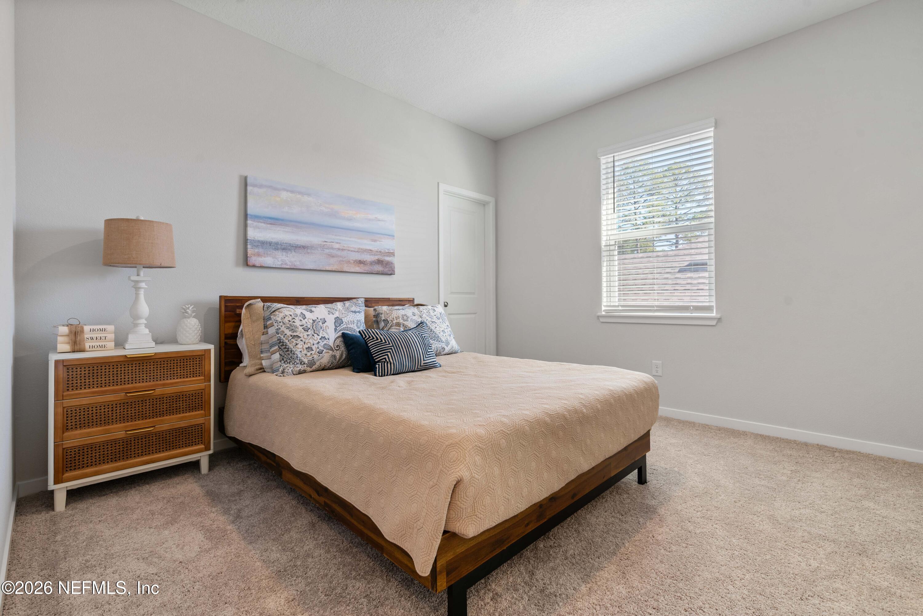 96245 Broadmoore Road Fernandina Beach, FL 32034 - Photo 24 of 33 a large bed sitting in a bedroom next to a window