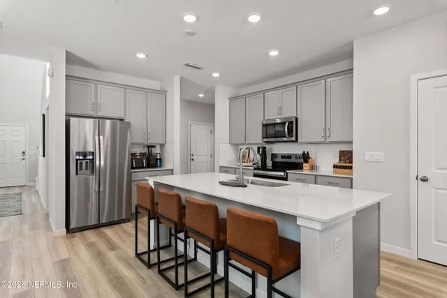 a kitchen with a refrigerator a stove a microwave and island with wooden floor