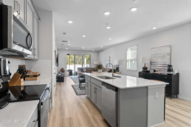 a kitchen with counter top space a sink a stove and cabinets