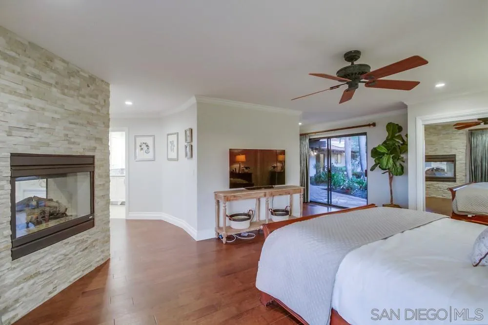 16062 Stoney Acres Road Poway, CA 92064 - Photo 42 of 75 a bedroom with furniture a flat screen tv and a fireplace