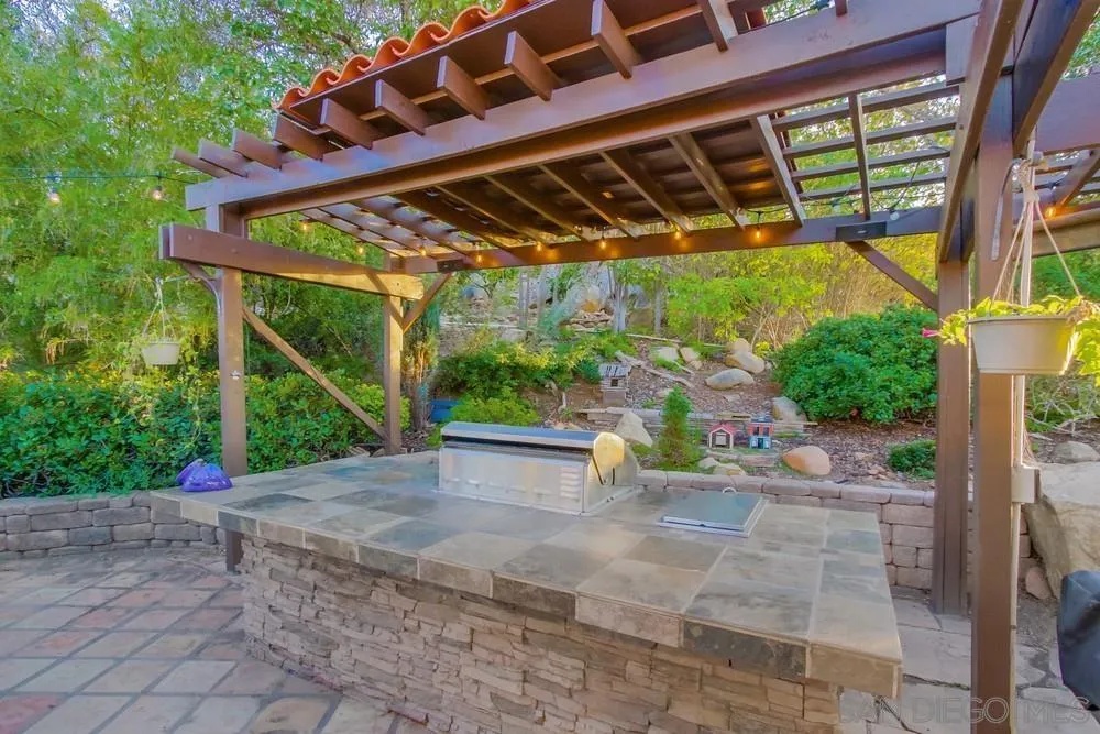 16062 Stoney Acres Road Poway, CA 92064 - Photo 57 of 75 a view of a patio with table and chairs under an umbrella